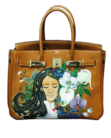 Hermès Birkin bag in tan leather with silver hardware and detailed embroidery of a woman and flowers
