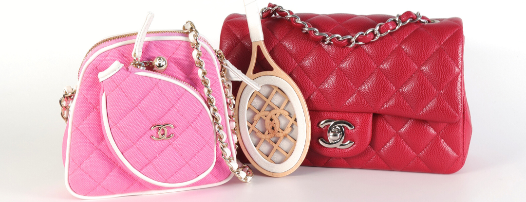 Pink and red quilted Chanel bags with gold and silver chain straps displayed alongside a vintage tennis racket.
