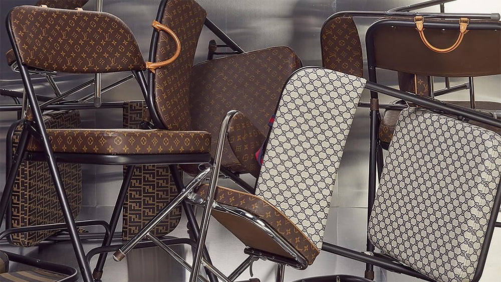 Several folding chairs covered with brown and beige Louis Vuitton monogram canvas with metal frames